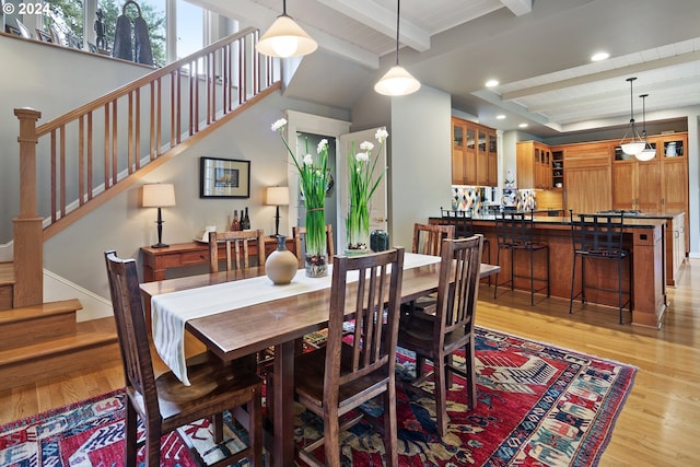 dining area featuring wooden ceiling, light hardwood / wood-style flooring, and beam ceiling