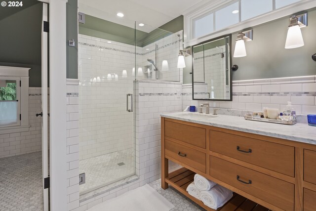 bathroom featuring tile walls, vanity, an enclosed shower, and tile patterned floors