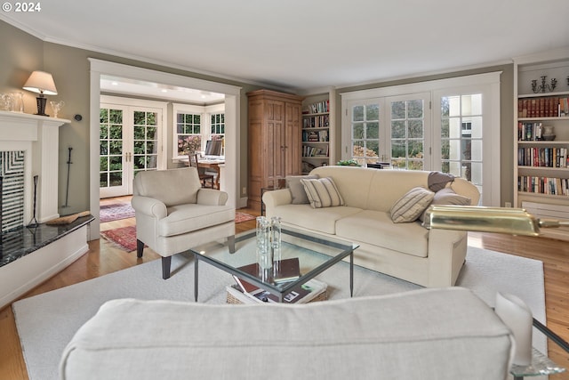 living room with french doors, light wood-type flooring, and ornamental molding