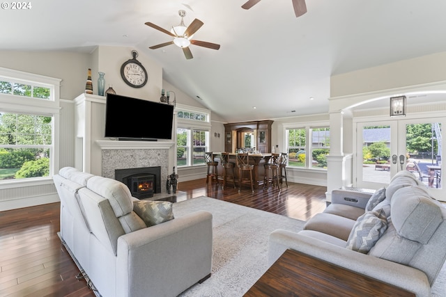 living room with a fireplace, french doors, dark hardwood / wood-style flooring, ceiling fan, and vaulted ceiling