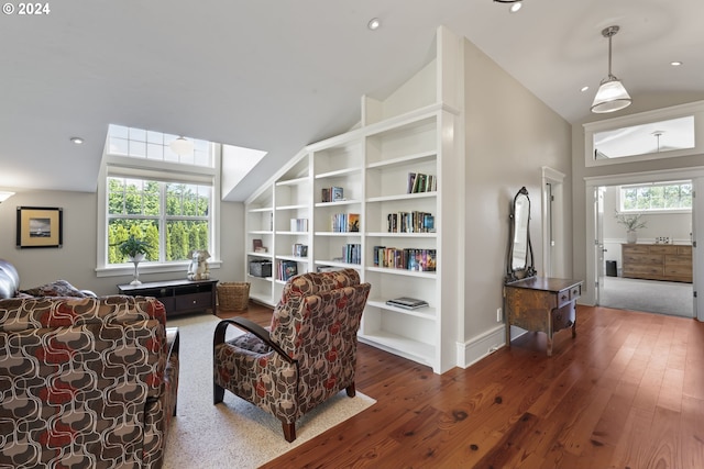 living area featuring a wealth of natural light, high vaulted ceiling, and dark hardwood / wood-style flooring