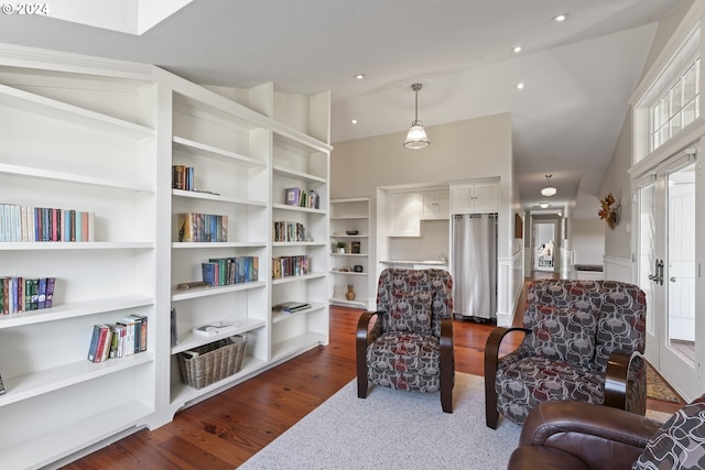 living area featuring lofted ceiling and dark hardwood / wood-style flooring