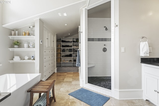 bathroom with a tile shower, vanity, and tile patterned floors