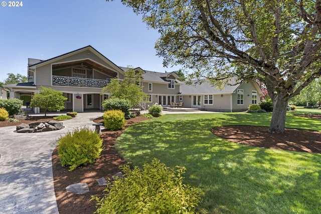 view of front of property with a patio area, a front yard, and a balcony