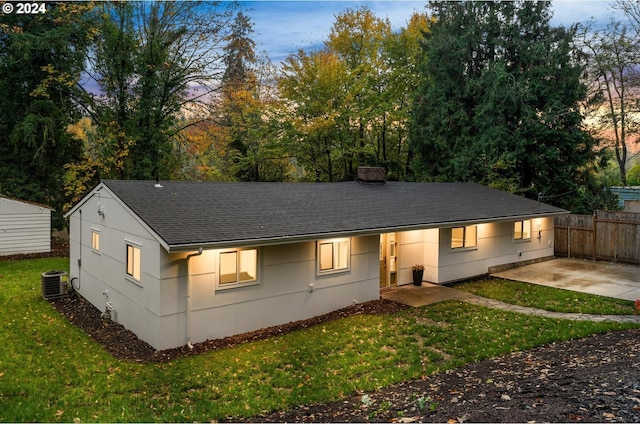 view of front of home with a patio area, a yard, and cooling unit