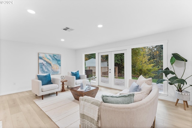 living room featuring french doors and light wood-type flooring