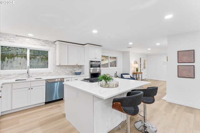 kitchen featuring a center island, sink, light wood-type flooring, and stainless steel appliances