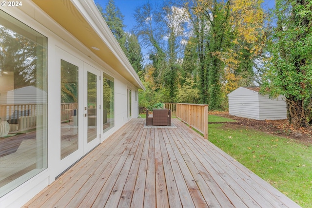 wooden deck with a yard, french doors, and a storage unit