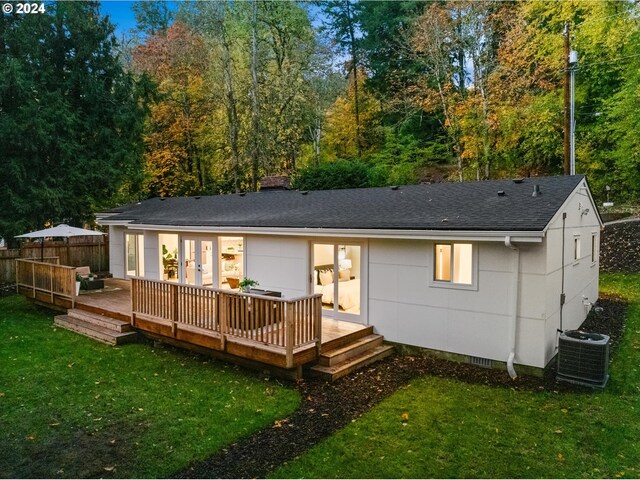 rear view of house featuring a wooden deck, a yard, and cooling unit