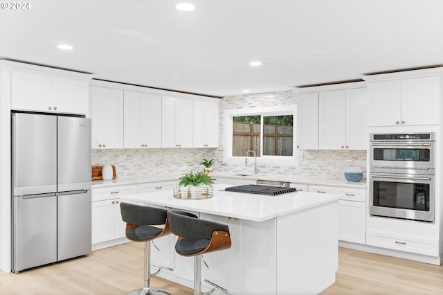 kitchen with appliances with stainless steel finishes, a kitchen island, and white cabinets