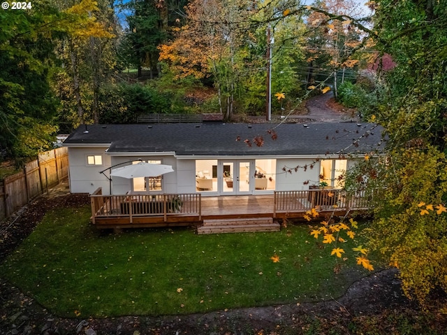 back of house featuring a lawn, a deck, and french doors