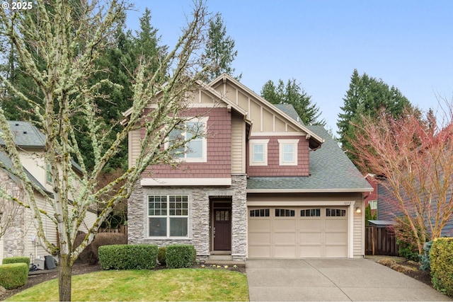 craftsman inspired home featuring a garage, a shingled roof, concrete driveway, stone siding, and a front lawn