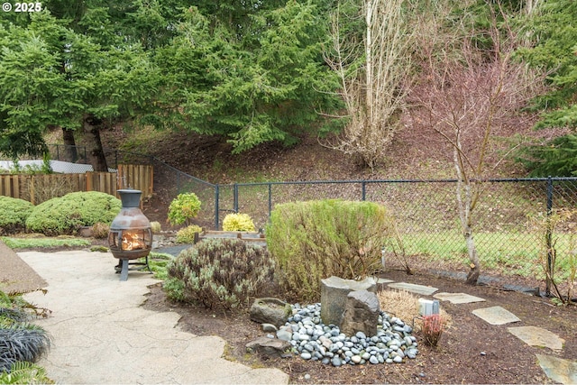 view of yard with a fire pit, a patio, and fence