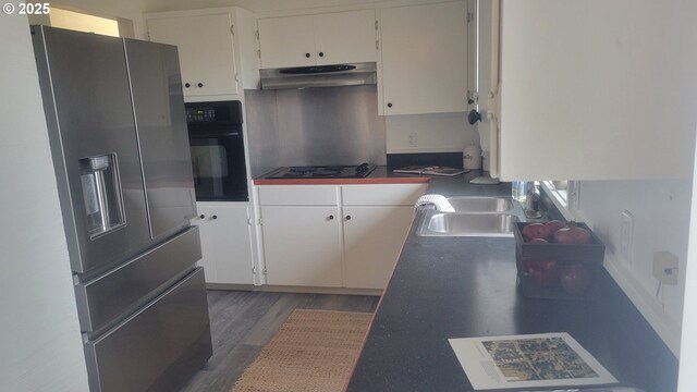 unfurnished living room with a wood stove, dark wood-type flooring, and washing machine and clothes dryer