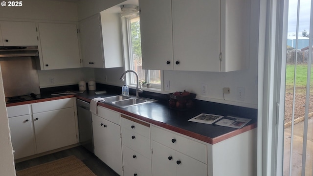 kitchen with dark countertops, a healthy amount of sunlight, white cabinetry, and a sink