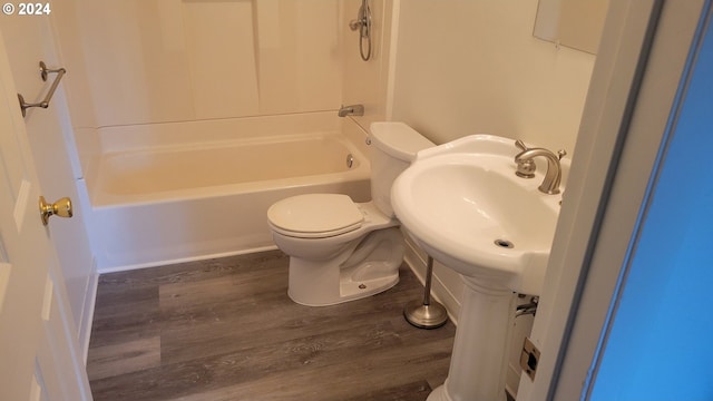 bathroom featuring toilet, hardwood / wood-style flooring, and tub / shower combination