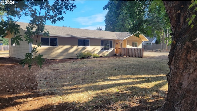 ranch-style home featuring a front yard and fence