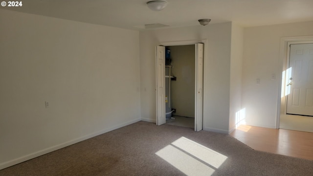 empty room featuring light colored carpet and baseboards