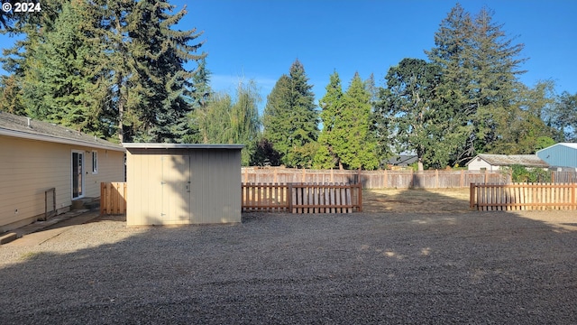 view of yard with fence, an outdoor structure, and a storage unit