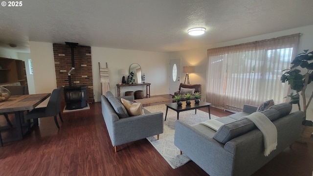 living area with a textured ceiling, dark wood-style flooring, and a wood stove