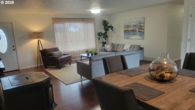 dining room featuring dark wood-type flooring, a textured ceiling, and baseboards