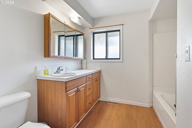 full bathroom with bathtub / shower combination, hardwood / wood-style floors, vanity, and toilet