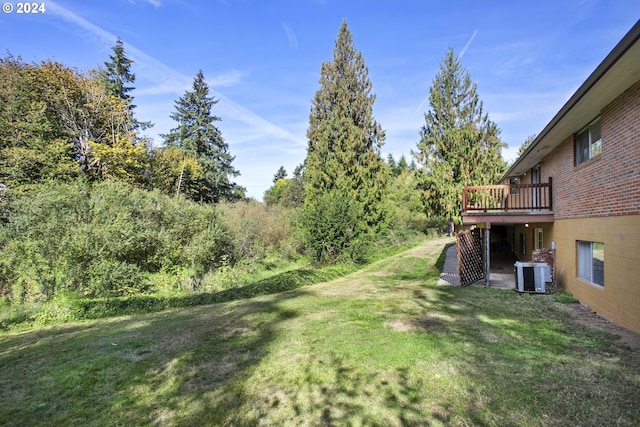 view of yard featuring a deck and central air condition unit