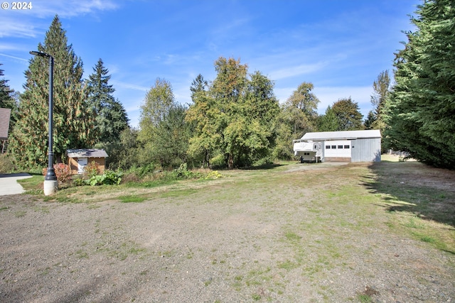 view of yard featuring a detached garage and an outdoor structure