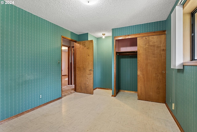 unfurnished bedroom with a textured ceiling and a closet