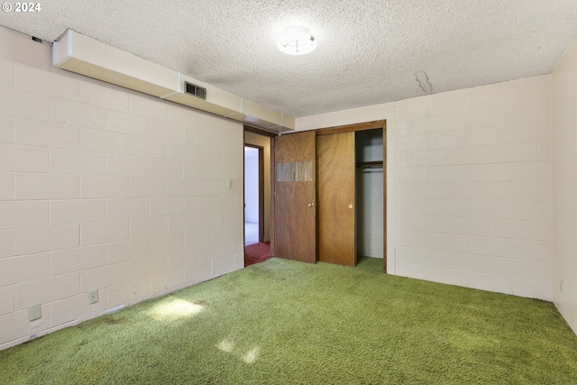 unfurnished bedroom featuring a textured ceiling, a closet, and carpet