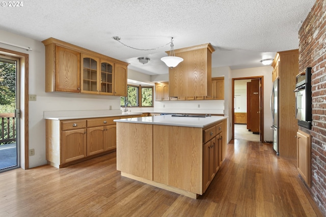 kitchen with plenty of natural light, oven, and light hardwood / wood-style flooring