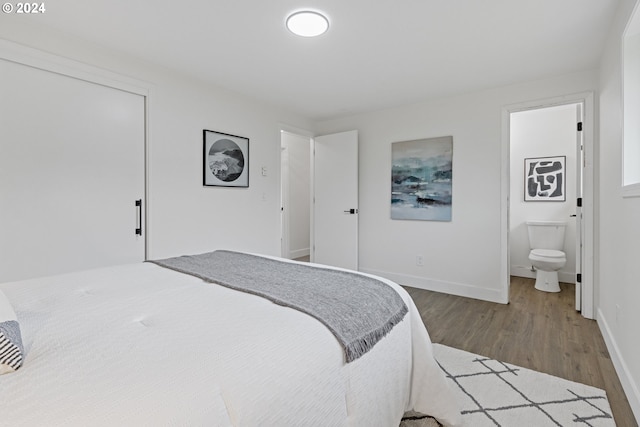 bedroom with hardwood / wood-style flooring and ensuite bath