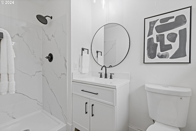 bathroom with vanity, toilet, and a tile shower