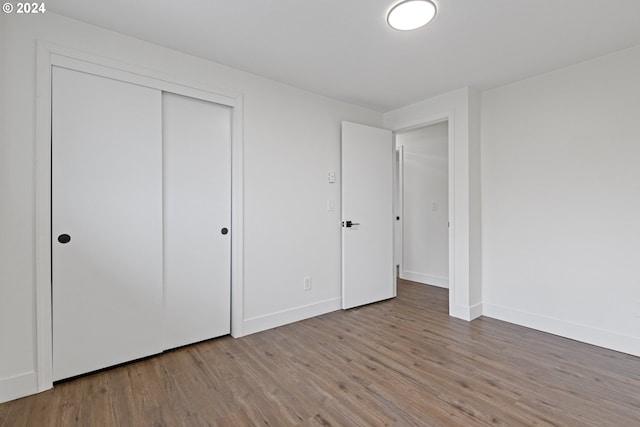 unfurnished bedroom featuring a closet and wood-type flooring