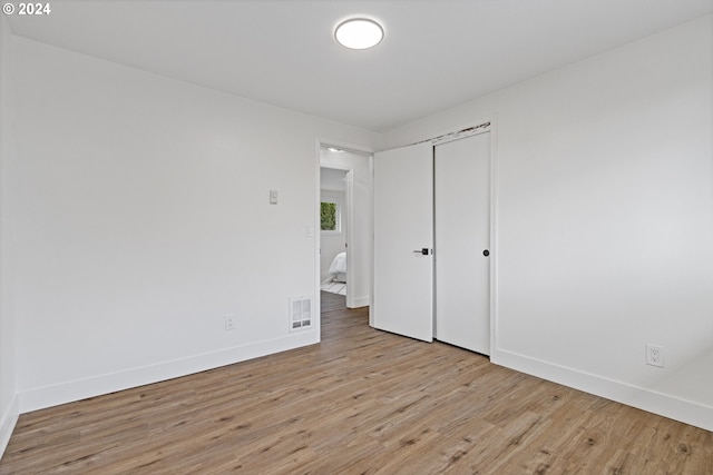 unfurnished bedroom featuring light hardwood / wood-style floors and a closet