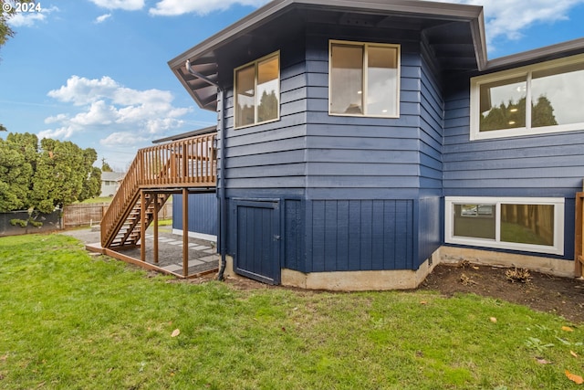 view of side of property featuring a lawn and a deck