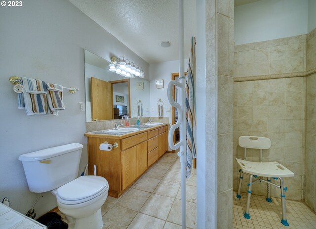 bathroom featuring toilet, a textured ceiling, vanity, and tile flooring