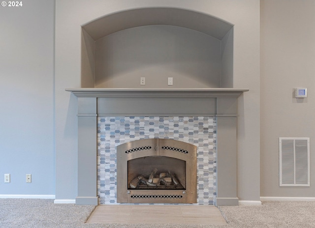 interior details featuring a fireplace and carpet