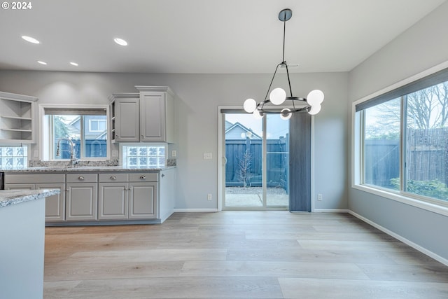 kitchen featuring gray cabinets, a wealth of natural light, and light hardwood / wood-style flooring