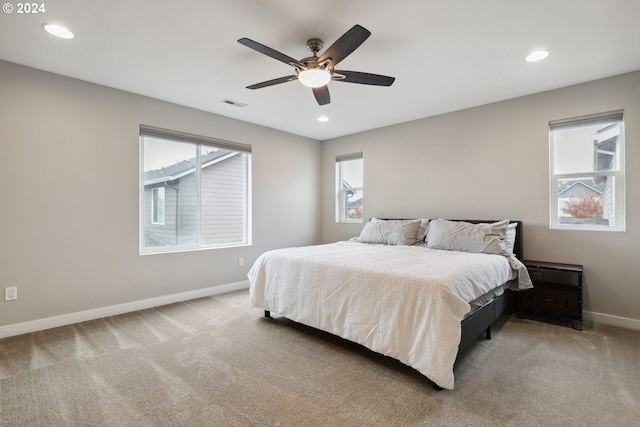 bedroom with carpet flooring, multiple windows, and ceiling fan