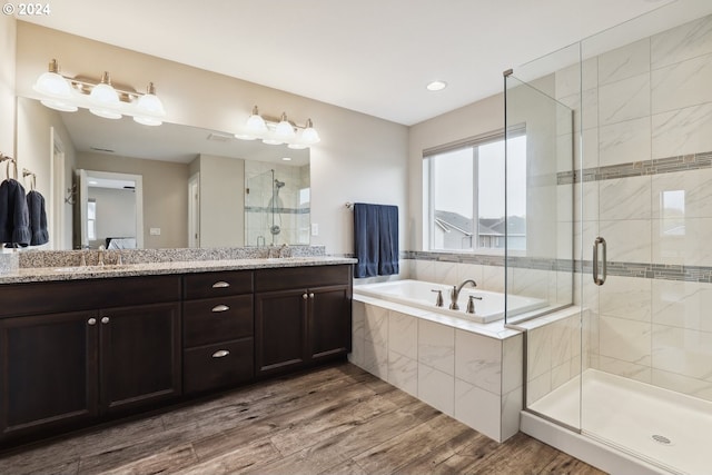 bathroom with vanity, independent shower and bath, and hardwood / wood-style flooring