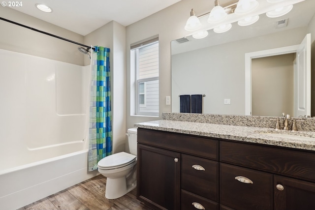 full bathroom featuring hardwood / wood-style floors, vanity, toilet, and shower / tub combo