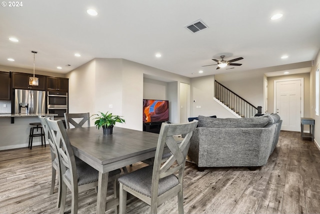 dining area with ceiling fan and wood-type flooring