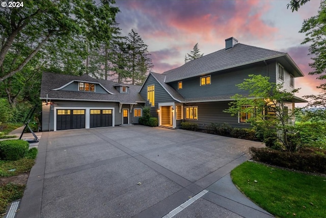 view of front of property with driveway, roof with shingles, and an attached garage