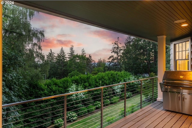 balcony at dusk featuring a grill