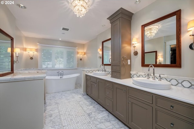 bathroom with a notable chandelier, vanity, and a washtub