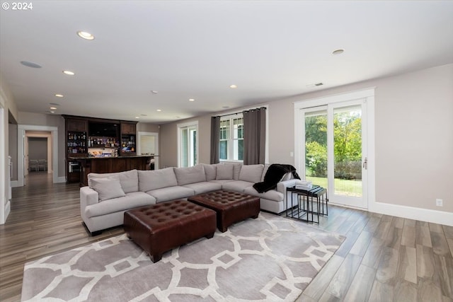 living room with light hardwood / wood-style floors and indoor bar