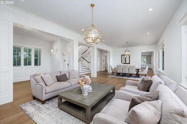 living room featuring hardwood / wood-style flooring, an inviting chandelier, and a tiled fireplace