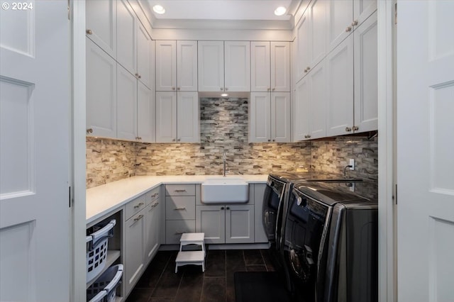 laundry area featuring cabinets, washing machine and dryer, dark wood-type flooring, and sink