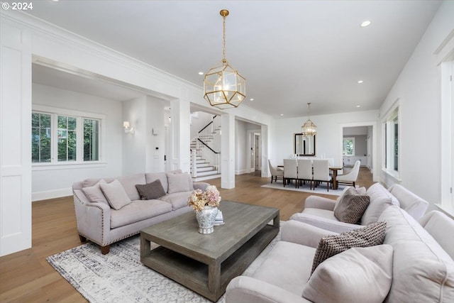 living room featuring light wood-type flooring and a notable chandelier